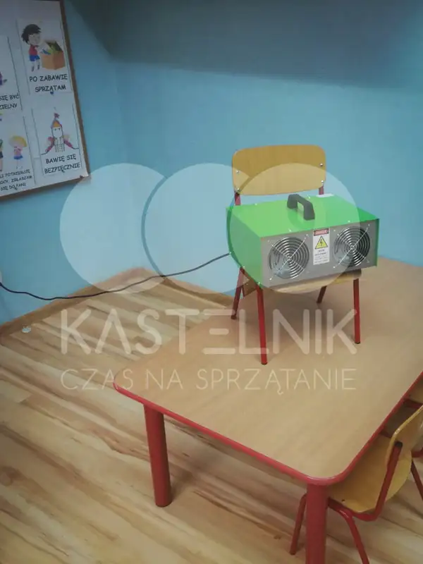 Kastelnik wykonuje ozonowanie sali przedszkola.